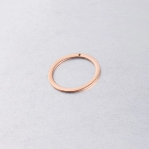 Macro detail of a rose gold circular pendant with a small hole for DIY jewelry making