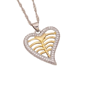 Collier avec pendentif cœur bicolore et pierres CZ sur chaîne argentée sur fond blanc