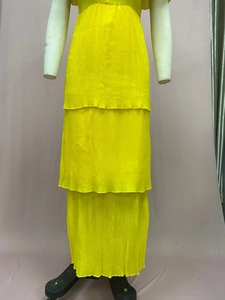 Nahaufnahme des gelben Chiffon-Maxikleids mit feiner Plissierung auf einer Schaufensterpuppe