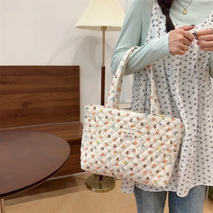 Quilted tote bag detail featuring orange floral and bear patterns for daily use