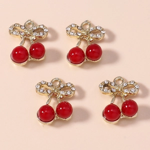 Detailed close-up of four red cherry alloy pendants with gold leaves and clear rhinestones