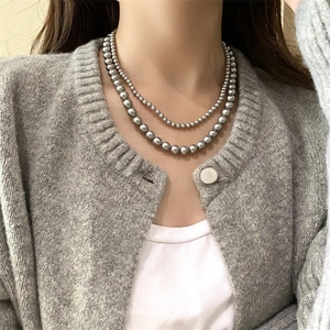 Close-up of elegant double-layer metallic grey pearl necklace on a model