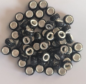 Macro shot of 12mm black clay beads with crystal rhinestones and silver metal core