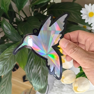 Detailed holographic hummingbird suncatcher showing vibrant rainbow prism reflections
