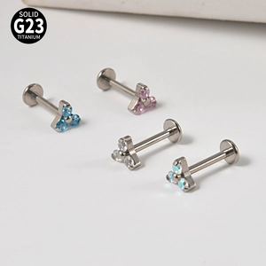 Detailed close-up of G23 titanium labret studs with triangle opal and zircon flower tops