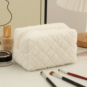 Close-up of white plush pencil case with quilted texture and metal zipper detail