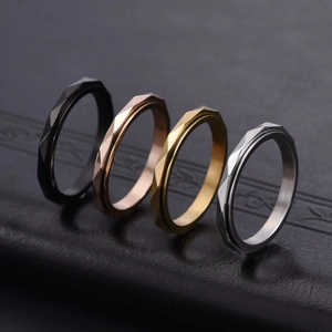 Macro detail of rotating stainless steel rings with geometric diamond cut pattern in four colors