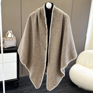 Detail of khaki wool shawl featuring white zigzag stitch edges and soft warm texture
