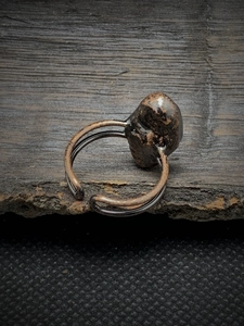 Macro detail of vintage adjustable bronze ring with irregular raw natural brown stone