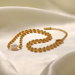 Detail of freshwater pearl necklace with gold bead chain on premium silk background