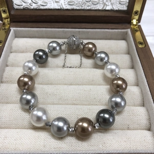 Close-up of mixed Morandi color pearls with diamond magnetic clasp in a wooden jewelry box