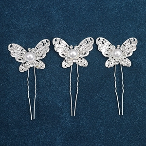 Detail view of silver butterfly hair pins with hollow wings, rhinestones and pearls