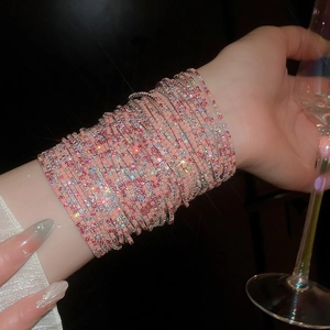 Detail of pink crystal multi-layer stretch bracelet sparkling on wrist in dark party light