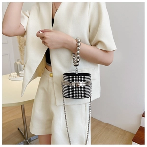 Detail of black cylinder evening bag with silver rhinestones and beaded handle