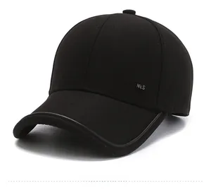 Detail of metal NLS logo and leather trim on a black twill outdoor baseball cap