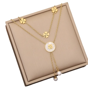 Golden double-layer clover necklace with shell inlay and pearl fringe on jewelry box