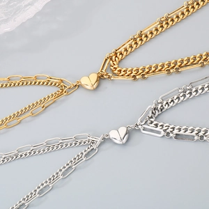 Detail of gold and silver layered bracelets featuring heart magnetic clasps on link chains