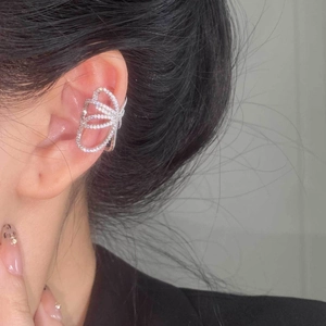 Detail of silver butterfly ear cuff with sparkling zircons worn on the middle ear