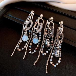 Détail de boucles d'oreilles luxe à pompons gouttes d'eau avec cristaux et aiguilles d'argent
