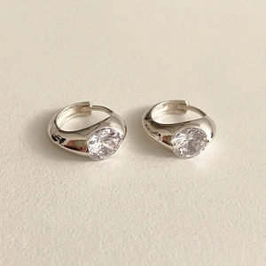 Close-up of S925 sterling silver huggie earrings with round cubic zirconia in bezel setting