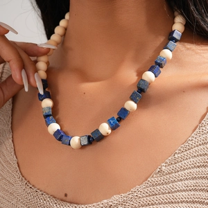 Détail d'un collier bohème avec perles cubiques bleues et perles en bois rondes beige