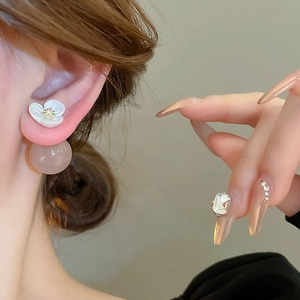 Vintage floral stud earrings with light pink resin bead on model's ear in close-up shot