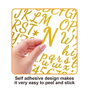 Detail of peeling a 1.5 inch gold glitter letter sticker showing strong self-adhesive back