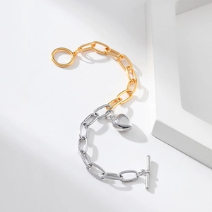 Two-tone gold and silver chain bracelet with heart pendant and toggle clasp on white background