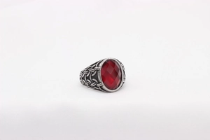 Detailed shot of retro silver ring with red faceted gemstone and woven texture