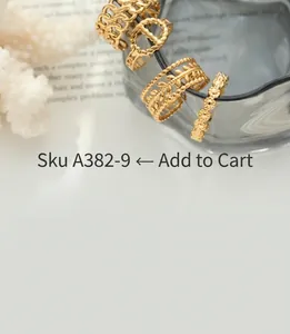Close-up of gold chunky chain rings and pearl bracelets displayed on coral and glass
