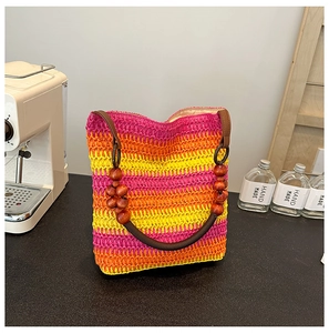 Close-up of rainbow gradient woven bucket bag featuring elegant round wooden bead handles