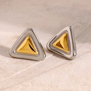 Macro detail of geometric triangle earrings in silver and gold polished stainless steel