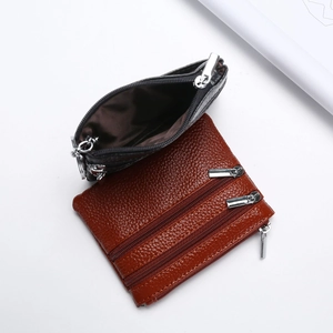 Detail of multi-layer leather coin purse with silver zippers and lychee texture