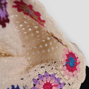 Close-up of handmade crochet lace pattern with colorful floral 3D embroidery detail