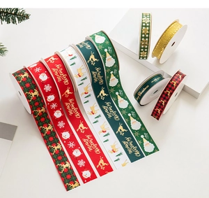 Close-up of assorted Christmas ribbons with gold stamping and holiday patterns on props