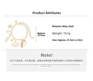 Detail view of gold-tone charm bracelet featuring starfish and seashell ornaments