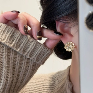 Macro view of crystal flower earrings with gold plating on elegant feminine ear