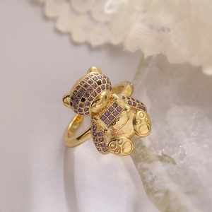 Detail of 18K gold-plated open ring featuring a cute bear paved with purple zircons
