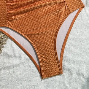 Makroaufnahme von orangefarbenem Bademodenstoff mit Zickzack-Muster und robusten Nähten