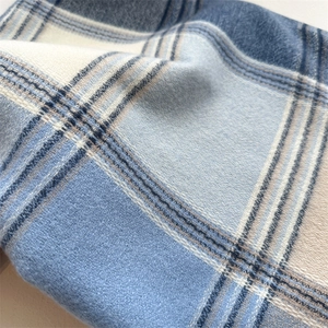 Detail view of soft thick blue plaid cashmere-feel scarf with brushed texture and fringes