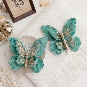 Double-layered turquoise Christmas butterfly ornaments with gold edges and velvet texture
