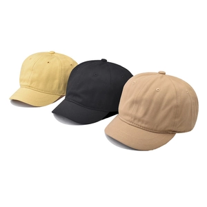 Casquettes de baseball à bord court en jaune moutarde, noir et kaki sur fond blanc
