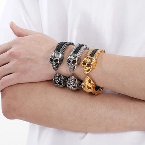 Men's skull steel wire bracelets in gold and silver finishes shown on a wrist