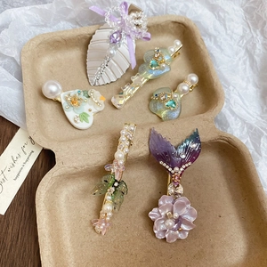 Vue détaillée de barrettes à fleurs avec strass et perles dans une boîte cadeau brune