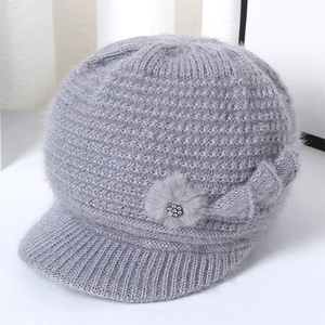 Detailed view of gray knit winter hat with plush flower decor and rhinestone accents