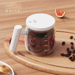 Detailed view of white electric self-stirring glass mug with 400ml scale on wooden tray
