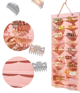 Detail of pink wall-mounted hair claw organizer showing sturdy stitching and easy access