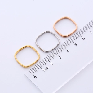 Detailed view of square titanium rings in gold, silver, and rose gold with a ruler scale