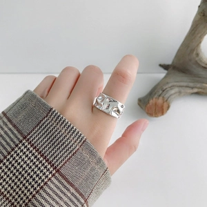 Irregular textured wide band ring in silver finish with minimalist hammered surface