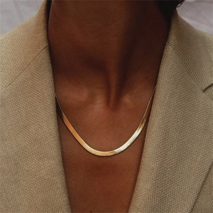 Flat gold snake chain necklace shown on a beige blazer for an elegant minimalist look